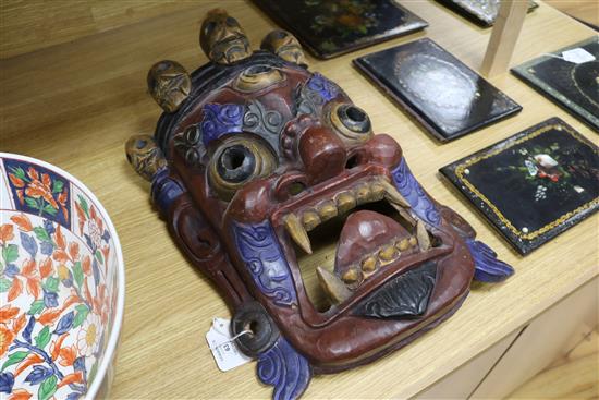 A Tibetan carved wood mask length 44cm approx.